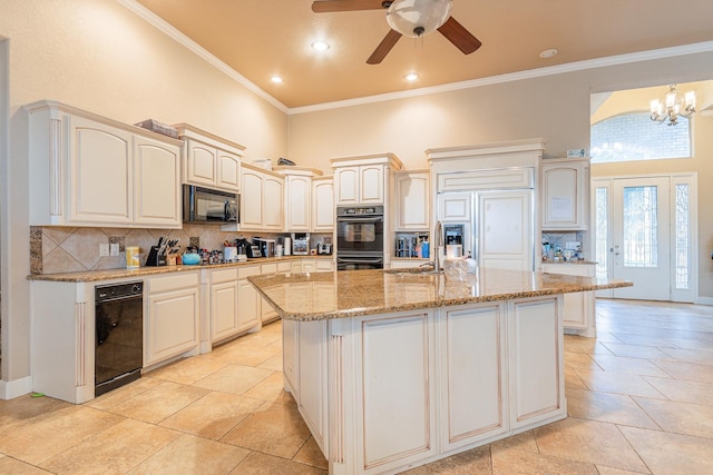 kitchen with a center island with sink, a towering ceiling, black appliances, hanging light fixtures, and decorative backsplash