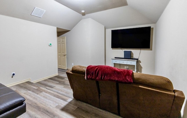 living room featuring hardwood / wood-style flooring and vaulted ceiling