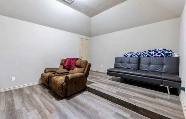 living area with vaulted ceiling and light hardwood / wood-style flooring