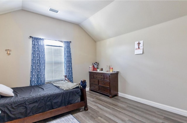 bedroom with light wood-type flooring and lofted ceiling