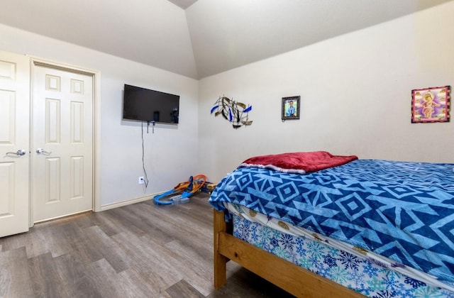 bedroom featuring hardwood / wood-style flooring and lofted ceiling