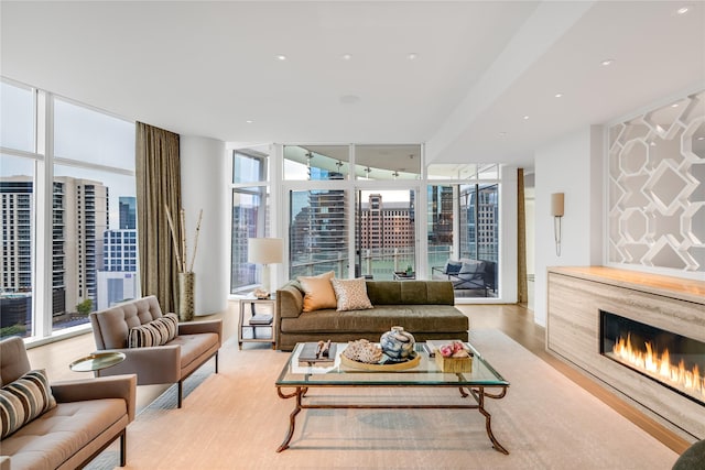 living room featuring light hardwood / wood-style floors, floor to ceiling windows, and a high end fireplace