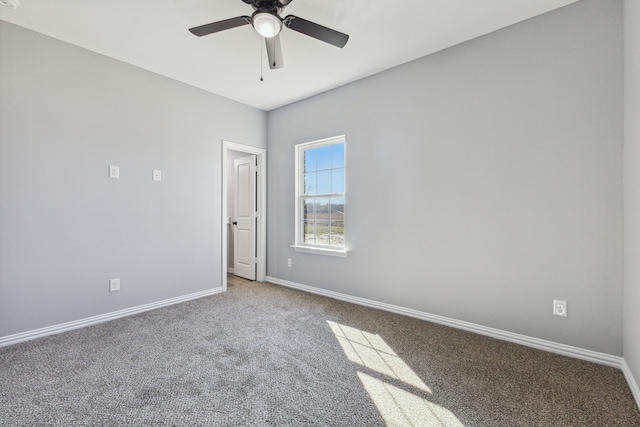 empty room featuring ceiling fan and carpet