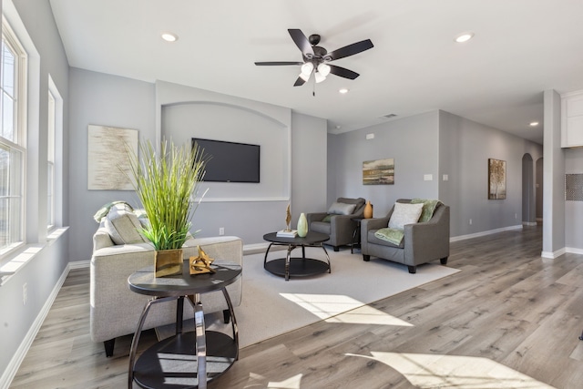 living room featuring light wood-type flooring and ceiling fan