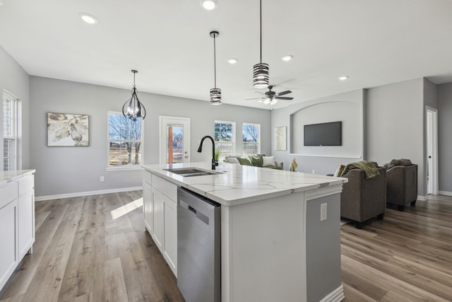 kitchen with a center island with sink, sink, dishwasher, and white cabinetry