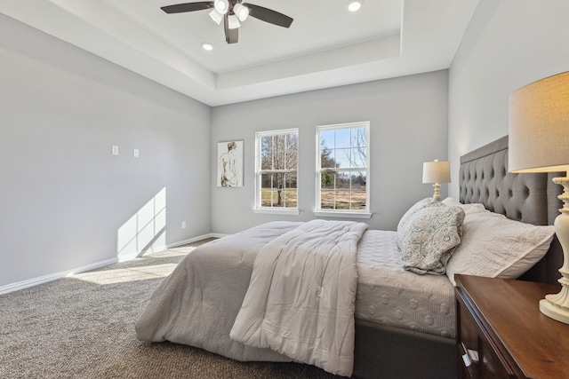 bedroom with carpet floors, ceiling fan, and a raised ceiling