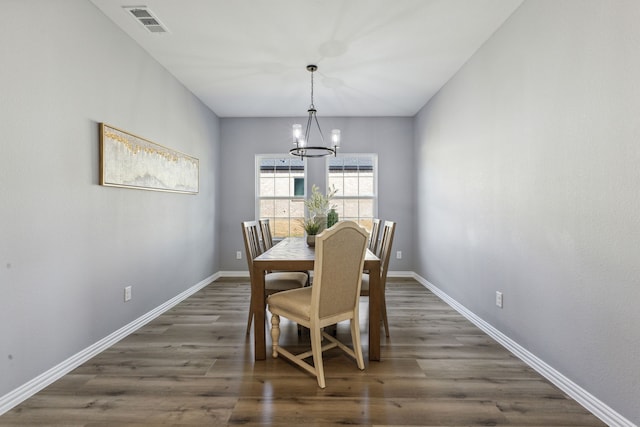 dining area with a notable chandelier and dark hardwood / wood-style floors