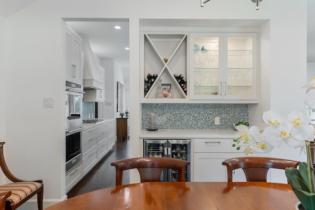 interior space with stainless steel appliances, white cabinetry, light countertops, and decorative backsplash