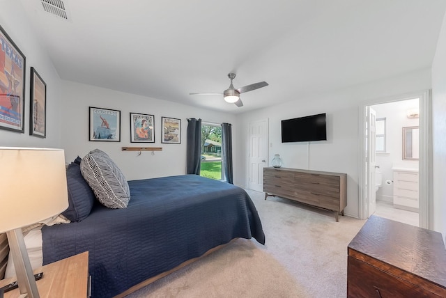 bedroom with a closet, visible vents, light carpet, ceiling fan, and ensuite bath