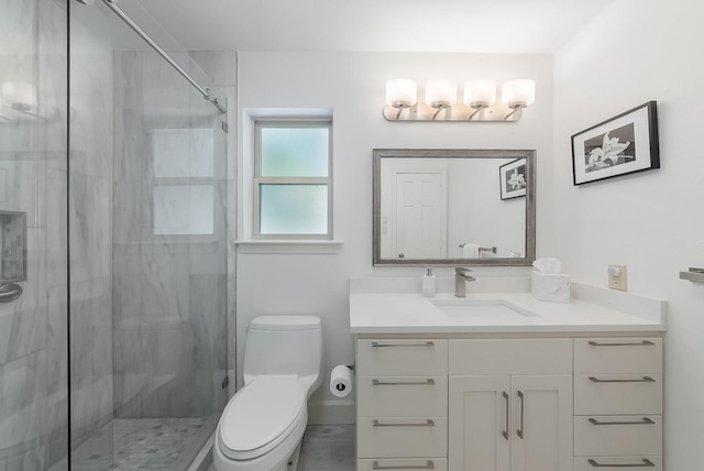 bathroom with vanity, a shower stall, and toilet