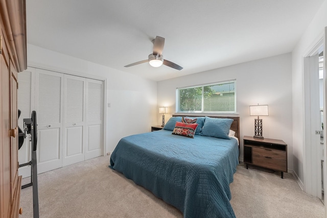 bedroom featuring a ceiling fan, a closet, and light colored carpet