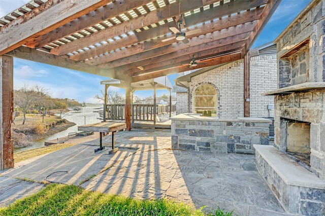 view of patio / terrace featuring an outdoor stone fireplace, a ceiling fan, and a pergola