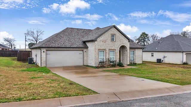 view of front of home featuring a garage, central AC unit, and a front lawn