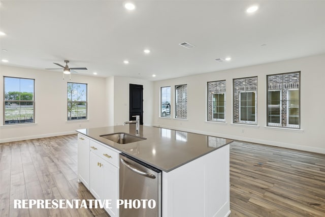 kitchen with sink, white cabinets, an island with sink, and light hardwood / wood-style floors