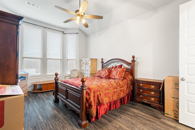 bedroom with dark wood-style flooring, visible vents, vaulted ceiling, and ceiling fan