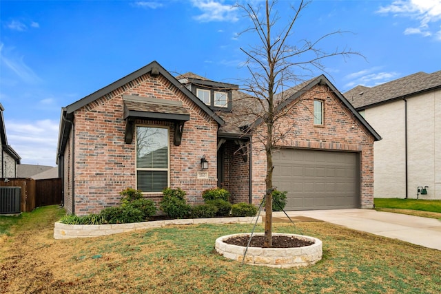 view of front of property featuring central AC unit, a front lawn, and a garage