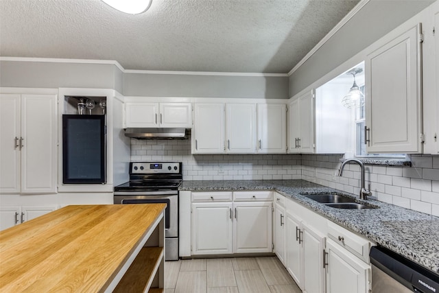 kitchen featuring sink, white cabinetry, stainless steel appliances, light stone countertops, and ornamental molding