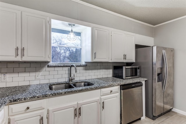 kitchen featuring appliances with stainless steel finishes, white cabinets, decorative backsplash, ornamental molding, and sink