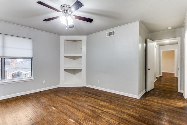 unfurnished room featuring ceiling fan, built in features, dark hardwood / wood-style floors, and ornamental molding