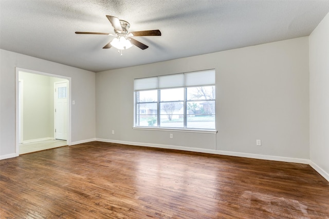 empty room featuring dark hardwood / wood-style flooring, ceiling fan, and a textured ceiling