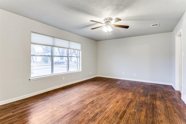 spare room with ceiling fan, dark wood-type flooring, and a textured ceiling