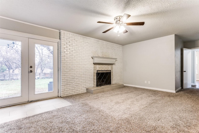 unfurnished living room featuring a fireplace, french doors, ceiling fan, a textured ceiling, and light carpet