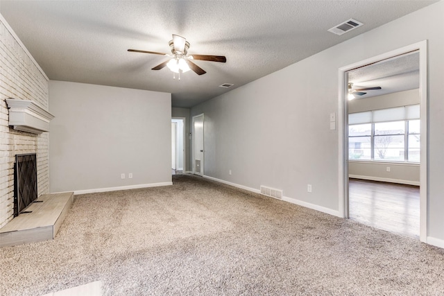 unfurnished living room with carpet, a brick fireplace, a textured ceiling, and ceiling fan