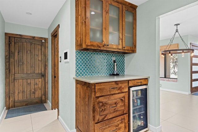 kitchen featuring light tile patterned flooring, decorative light fixtures, tasteful backsplash, and wine cooler