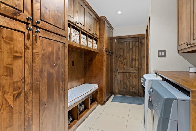 mudroom with light tile patterned flooring and separate washer and dryer