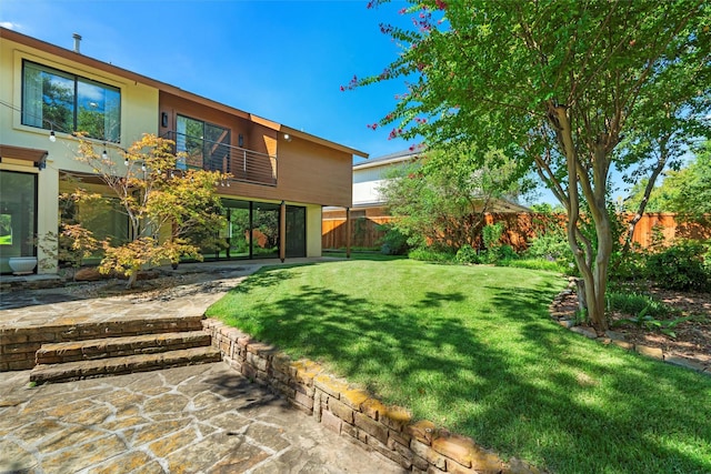 view of yard featuring a patio and a balcony