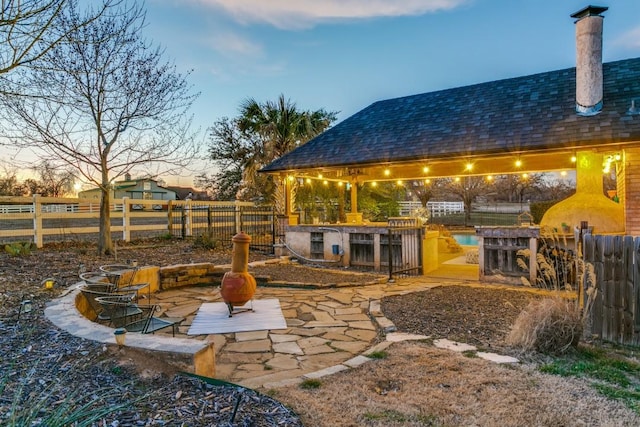 view of patio / terrace with an outdoor fire pit, fence, and a gazebo