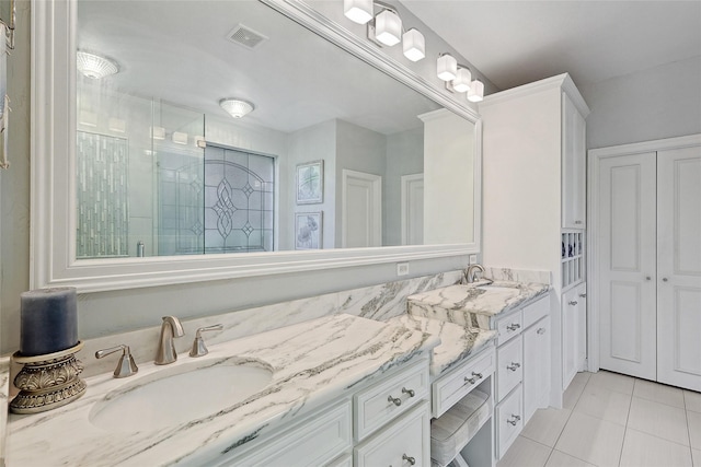 bathroom with a shower with door, tile patterned flooring, and vanity