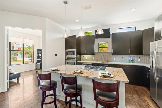 2123 Albany St, Dallas, TX 75201 - kitchen featuring sink, backsplash, a center island, decorative light fixtures, and stainless steel appliances