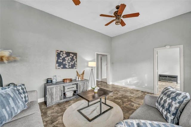 living area with baseboards and ceiling fan