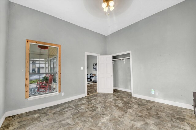 unfurnished bedroom with a closet, ceiling fan, and baseboards