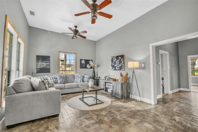 living room with baseboards, ceiling fan, visible vents, and vaulted ceiling