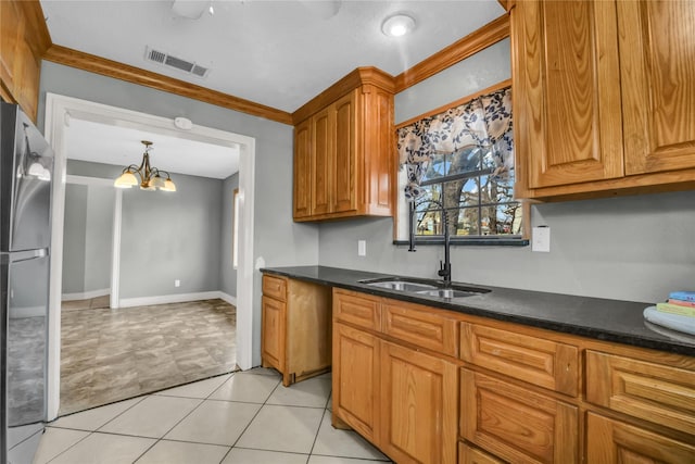 kitchen with an inviting chandelier, light tile patterned floors, a sink, freestanding refrigerator, and visible vents