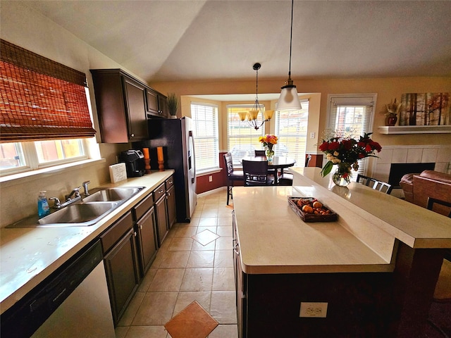 kitchen with lofted ceiling, a kitchen island, sink, dishwasher, and pendant lighting