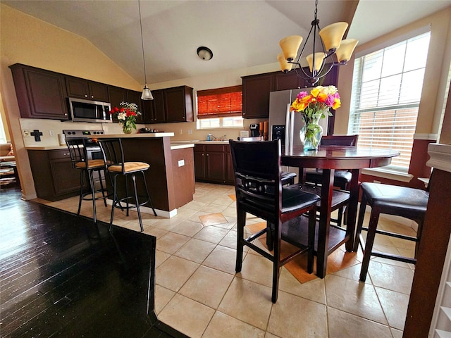 tiled dining area featuring an inviting chandelier and lofted ceiling