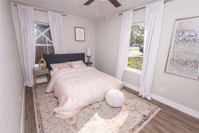 bedroom with a ceiling fan, baseboards, and wood finished floors