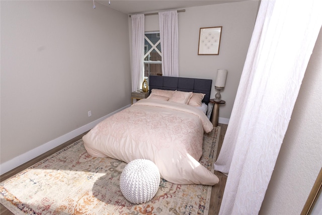 bedroom featuring baseboards and wood finished floors