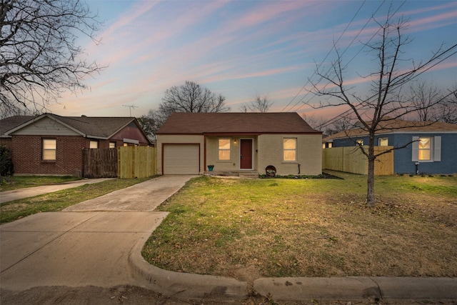 view of front of home featuring driveway, fence, a front lawn, and brick siding