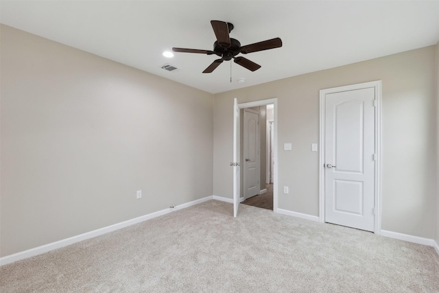 unfurnished bedroom featuring baseboards, visible vents, a ceiling fan, and light colored carpet