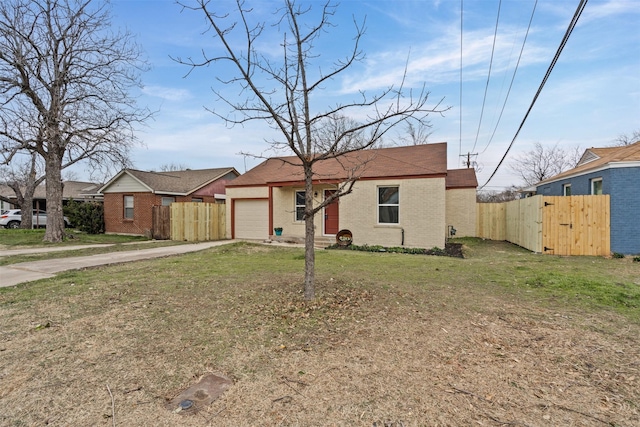 view of front of home with brick siding, fence, concrete driveway, a gate, and a front lawn