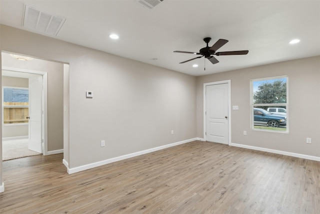 unfurnished room with baseboards, light wood finished floors, visible vents, and recessed lighting