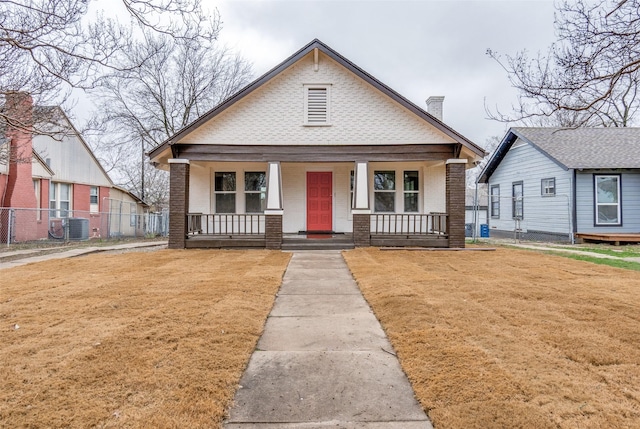 bungalow with central air condition unit, a front lawn, and a porch