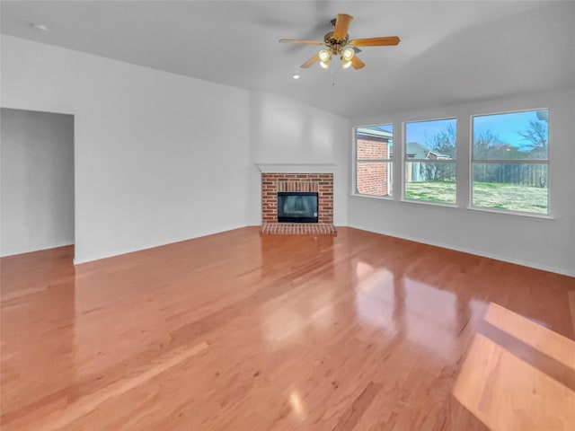 unfurnished living room featuring ceiling fan, a fireplace, and wood finished floors