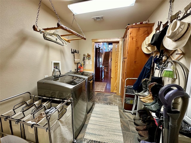 clothes washing area with independent washer and dryer and cabinets