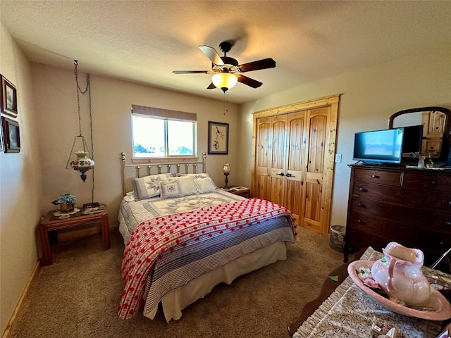 bedroom with a textured ceiling, carpet flooring, and ceiling fan