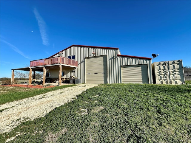 view of outdoor structure with a garage, a yard, and central air condition unit